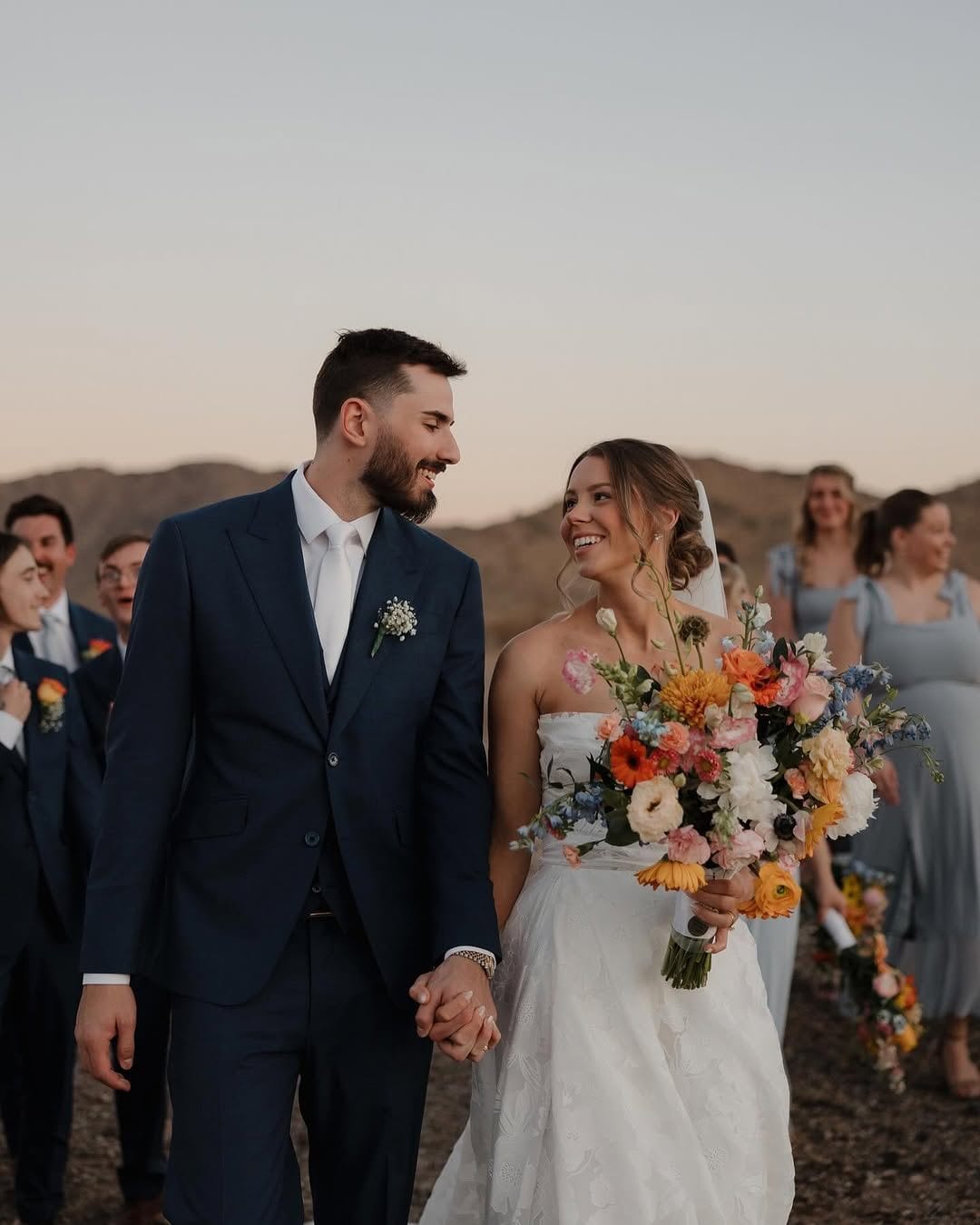 Bride and groom with bouquet and custom wedding suit