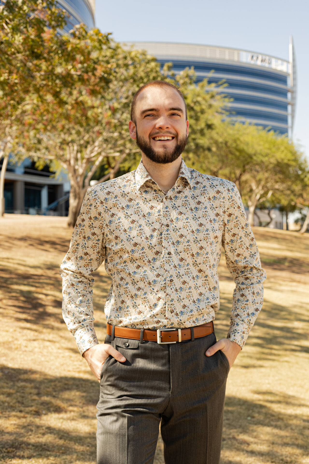 Man in floral print shirt and gray pants