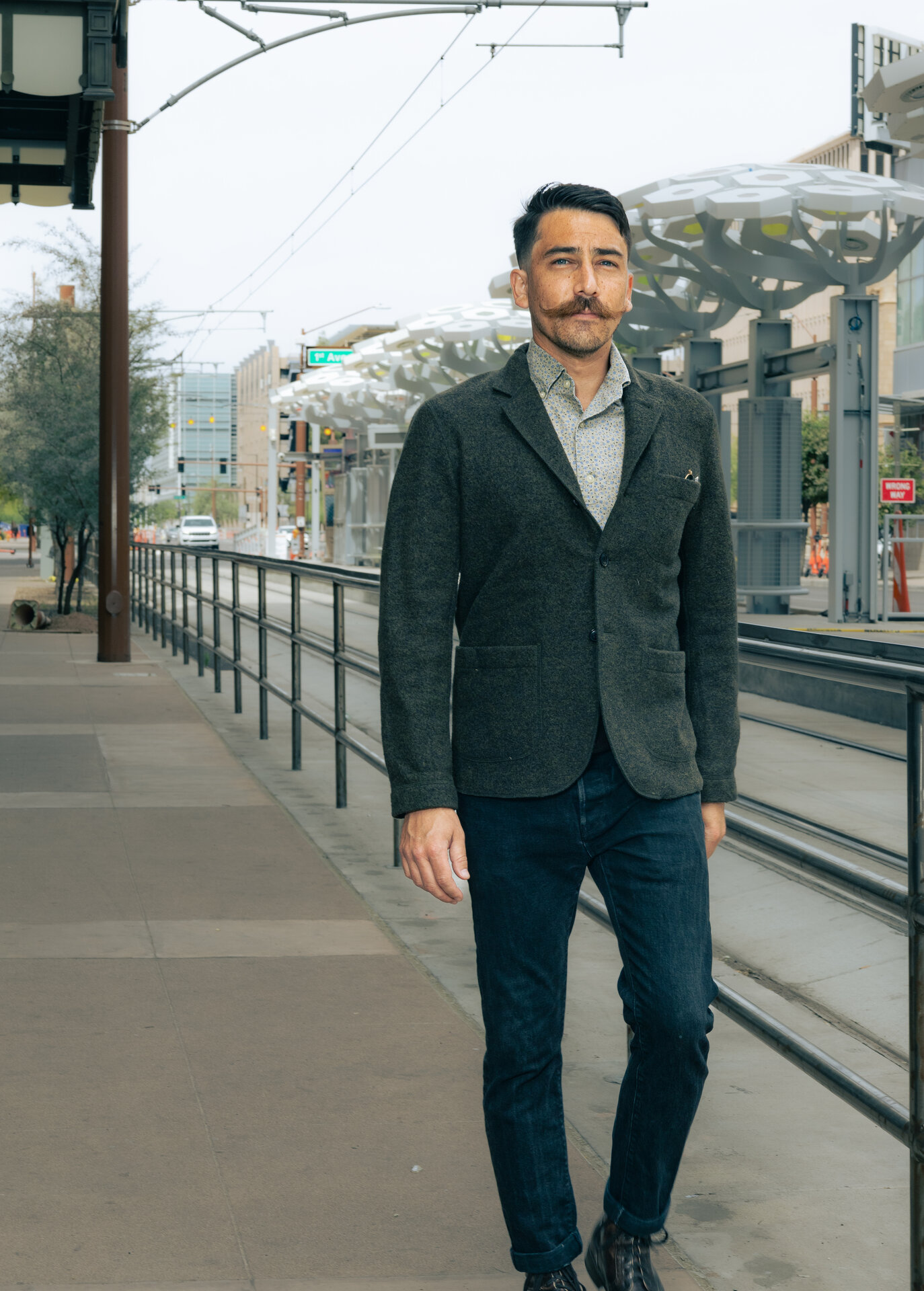 Man with mustache in gray blazer