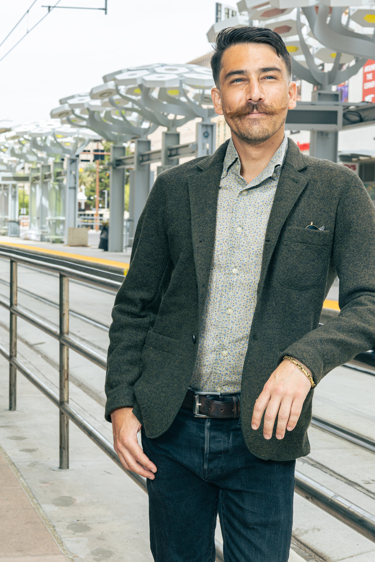 Man with mustache in gray blazer, side view