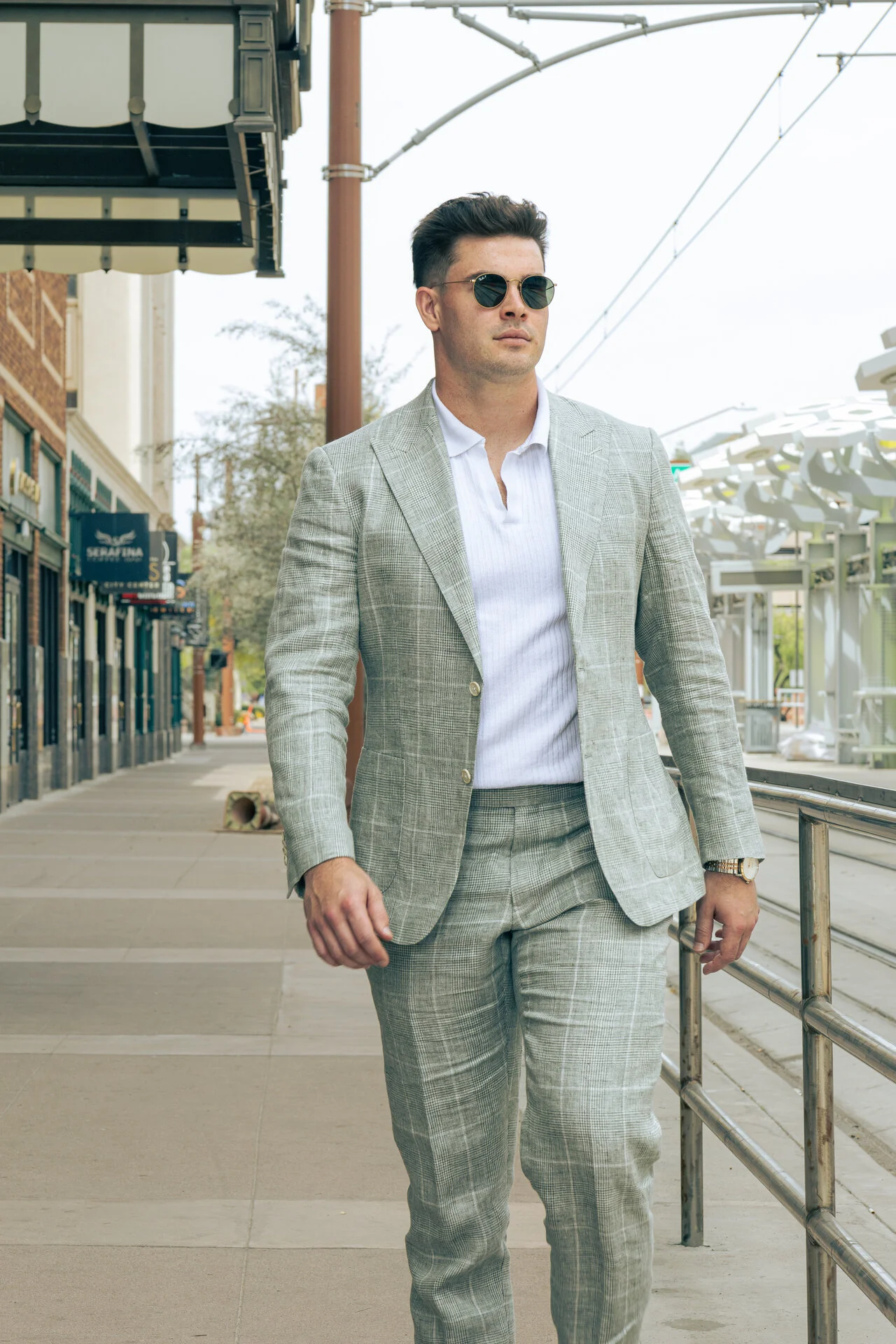 Man in light gray plaid suit walking