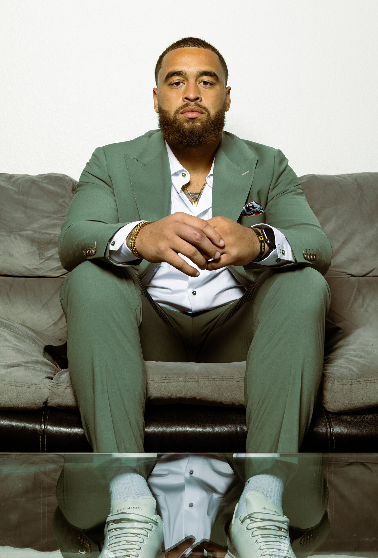 Man in mint green suit sitting on couch